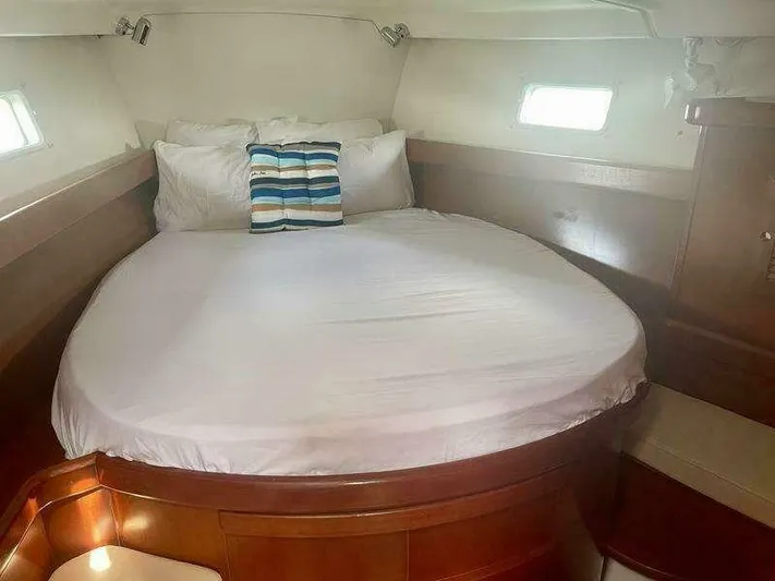  Yacht Photos Pics Cozy cabin interior of 2007 Beneteau 423 yacht with round bed and striped pillow.