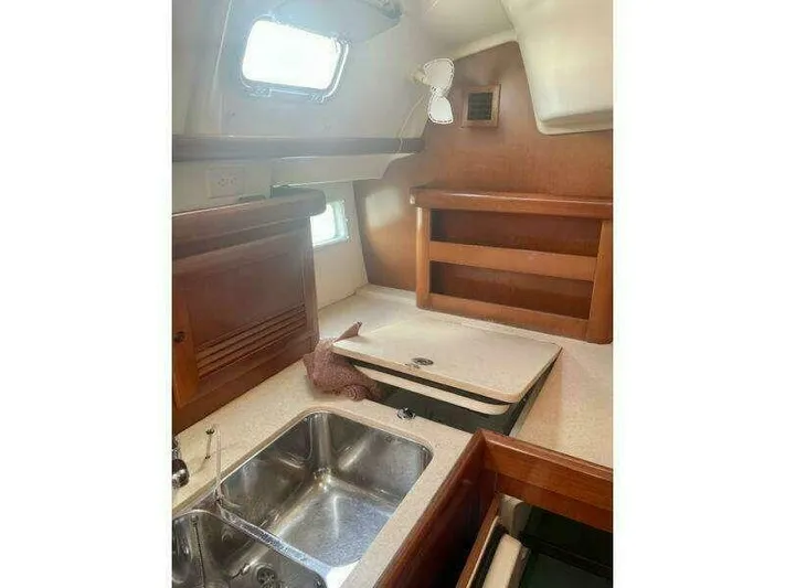 Yacht Photos Pics Interior of 2007 Beneteau 423 sailboat, featuring a compact kitchen with sink and wooden cabinetry.