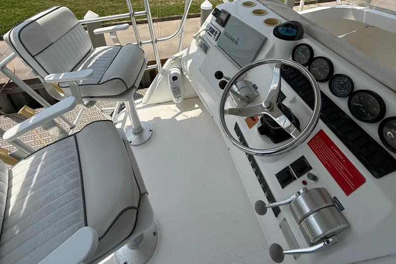  Yacht Photos Pics 2004 Luhrs 36 Convertible boat helm with steering wheel, gauges, and captain's chairs.