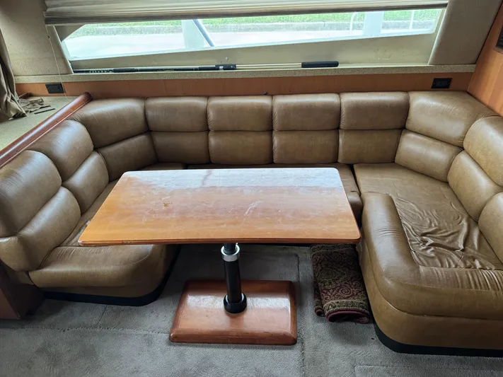  Yacht Photos Pics 2004 Luhrs 36 Convertible interior with brown leather seating and wooden table.