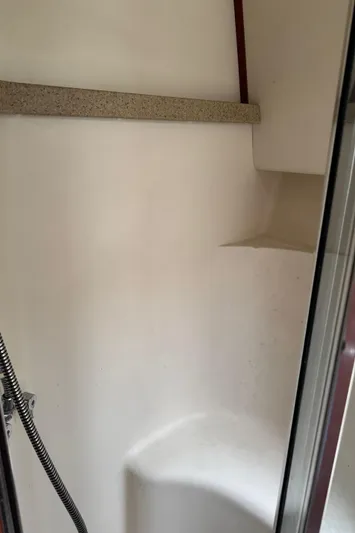  Yacht Photos Pics 2004 Luhrs 36 Convertible boat shower interior with white walls and chrome fixtures.