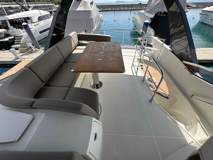  Yacht Photos Pics Luxurious 2013 Marquis 630 yacht with spacious deck seating and elegant wooden table.