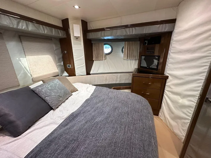 Yacht Photos Pics Luxurious bedroom interior of 2013 Marquis 630 yacht with cozy bedding and elegant wood finishes.