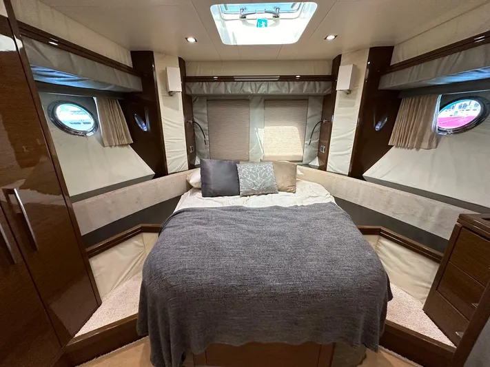  Yacht Photos Pics Luxurious 2013 Marquis 630 yacht bedroom with cozy bed, portholes, and elegant wood finishes.