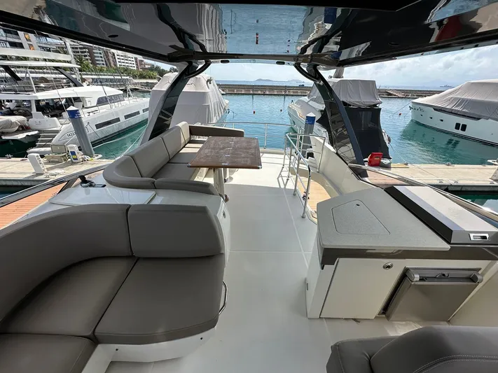  Yacht Photos Pics Luxurious 2013 Marquis 630 yacht interior with seating and table, docked at marina.