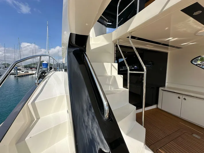  Yacht Photos Pics 2013 Marquis 630 yacht with sleek exterior and elegant staircase in a marina setting.