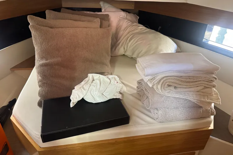  Yacht Photos Pics Interior of 2022 De Antonio Yachts D42 Open with cushions and folded linens on bed.