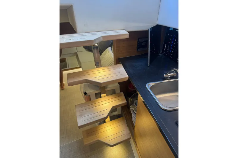 Yacht Photos Pics Interior view of 2022 De Antonio Yachts D42 Open, featuring wooden stairs and kitchenette.