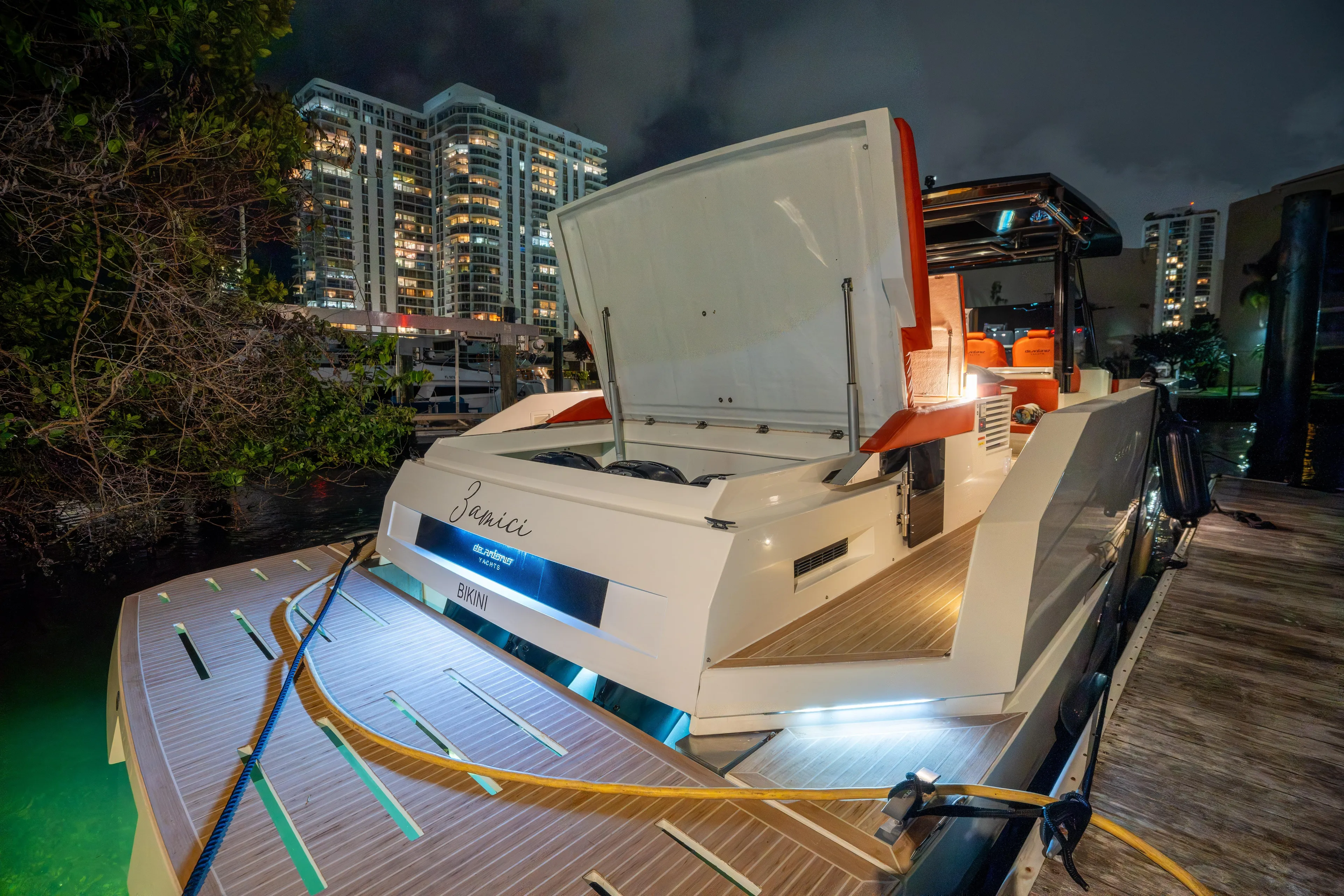  Yacht Photos Pics 2023 De Antonio Yachts D42 Open docked at night, city skyline in background.