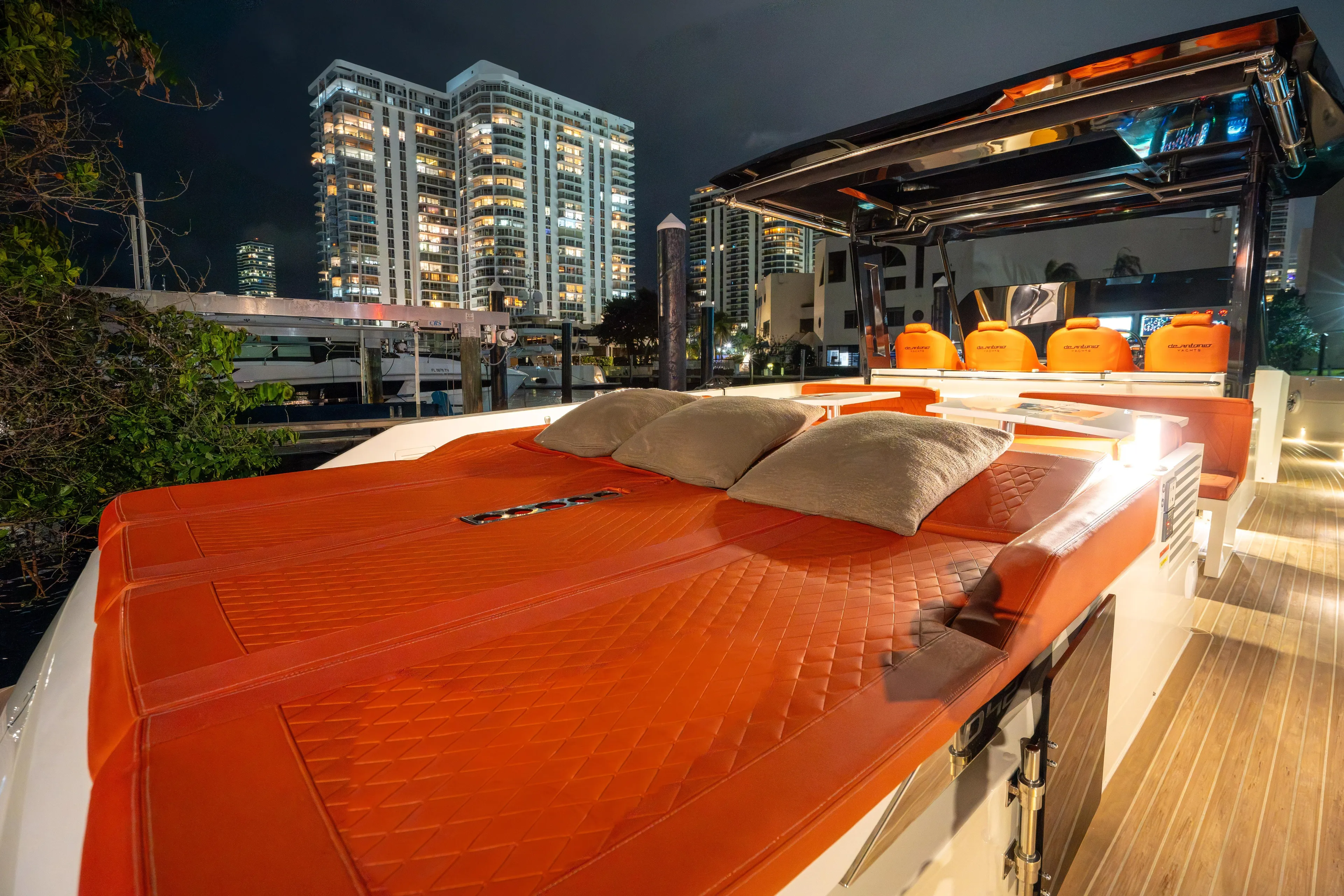  Yacht Photos Pics 2023 De Antonio Yachts D42 Open with luxurious orange seating, city skyline backdrop.