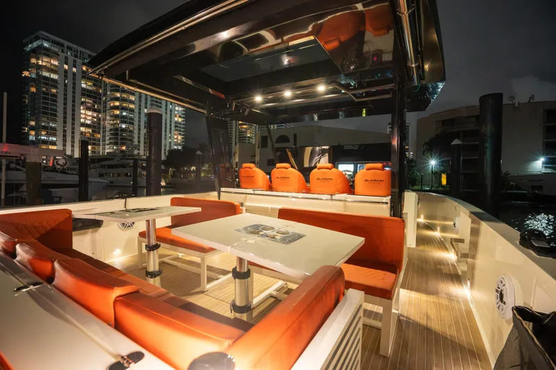  Yacht Photos Pics 2023 De Antonio Yachts D42 Open, luxurious deck with orange seating, city skyline at night.