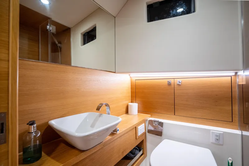  Yacht Photos Pics Luxurious bathroom interior of 2023 De Antonio Yachts D42 Open, featuring modern sink and wood accents.