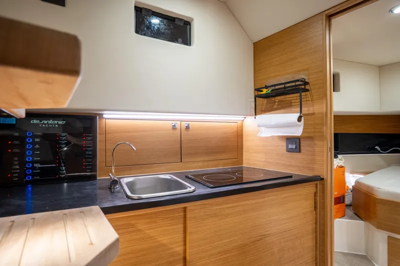  Yacht Photos Pics Modern kitchen interior of 2023 De Antonio Yachts D42 Open, featuring sleek wood finishes and compact design.