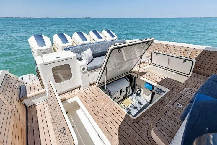  Yacht Photos Pics 2026 Scout 670 LXS boat with open deck compartments on a sunny day at sea.