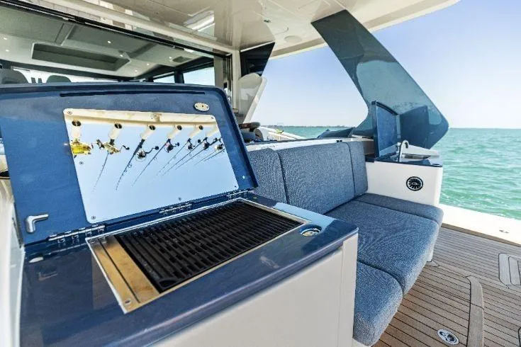  Yacht Photos Pics 2026 Scout 670 LXS boat interior with grill and blue seating, ocean view.