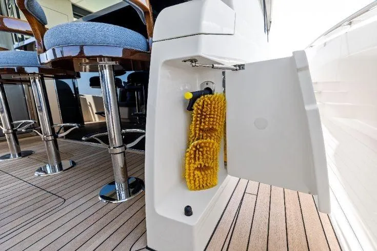  Yacht Photos Pics 2026 Scout 670 LXS boat with open storage compartment and cleaning brushes on deck.
