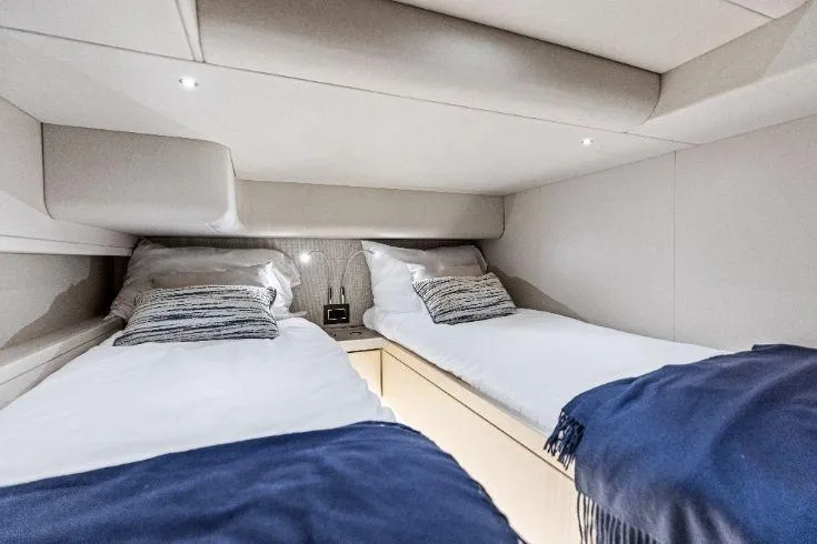  Yacht Photos Pics 2026 Scout 670 LXS cabin with twin beds, modern design, and cozy bedding.