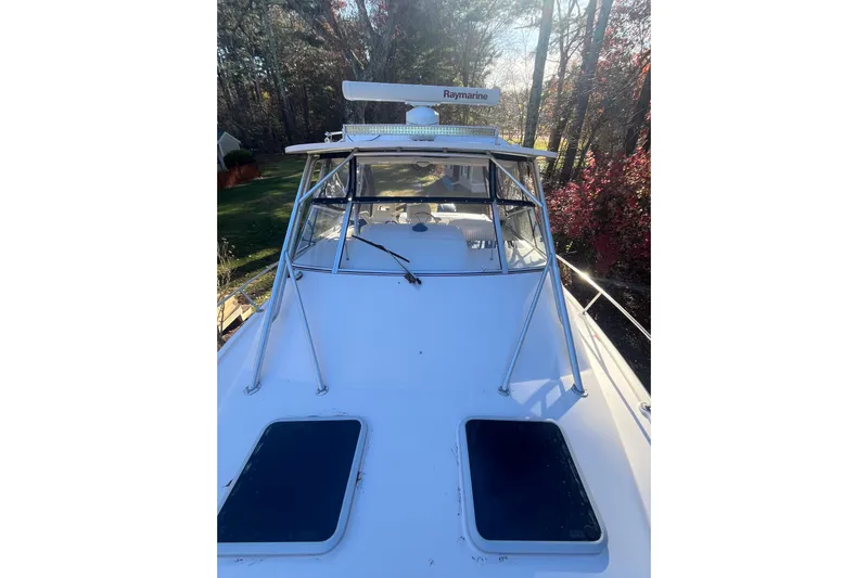 Revelry Yacht Photos Pics 2003 Grady-White Express 330 boat with Raymarine equipment, docked in a wooded area.