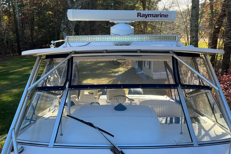 Revelry Yacht Photos Pics 2003 Grady-White Express 330 boat with Raymarine radar, docked in a wooded area.