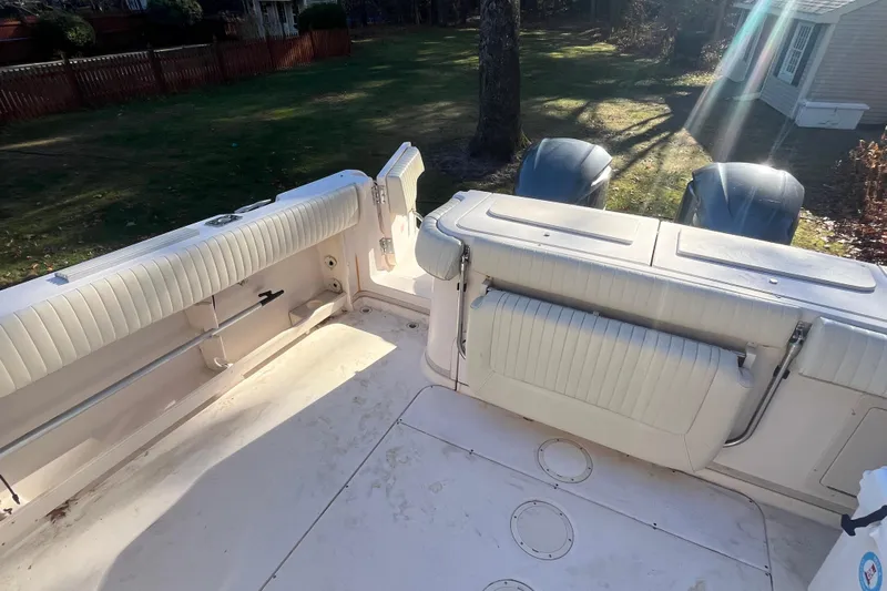 Revelry Yacht Photos Pics 2003 Grady-White Express 330 boat interior with seating and dual engines in a sunny yard.