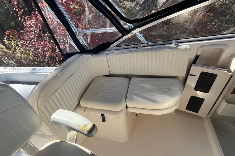 Revelry Yacht Photos Pics 2003 Grady-White Express 330 boat interior with white cushioned seating and windows.