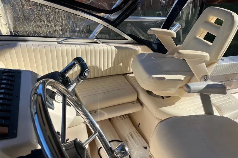 Revelry Yacht Photos Pics 2003 Grady-White Express 330 boat interior with steering wheel and captain's chair.