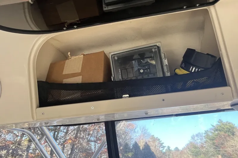 Revelry Yacht Photos Pics Storage compartment on a 2003 Grady-White Express 330 boat with various items.