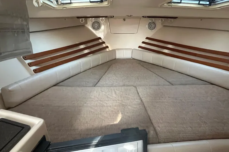 Revelry Yacht Photos Pics 2003 Grady-White Express 330 cabin interior with cushioned seating and wooden accents.