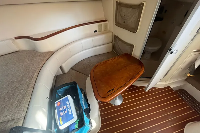 Revelry Yacht Photos Pics Interior of 2003 Grady-White Express 330 boat with seating, table, and first aid kit.
