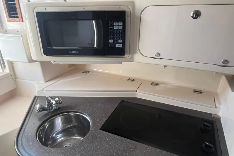 Revelry Yacht Photos Pics 2003 Grady-White Express 330 boat kitchen with microwave, sink, and stove.