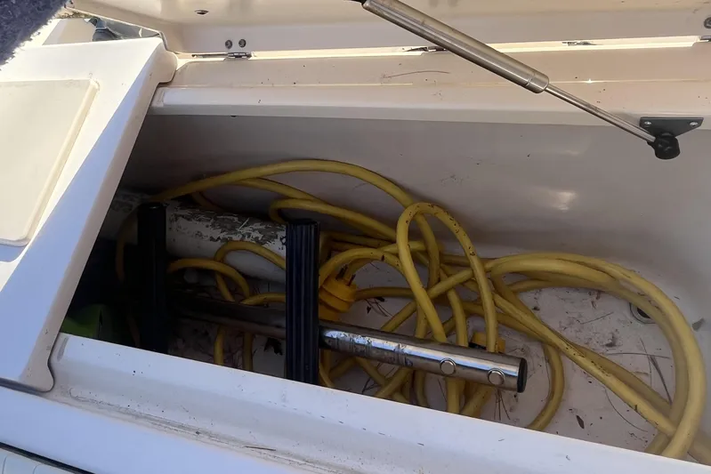 Revelry Yacht Photos Pics Storage compartment on a 2003 Grady-White Express 330 boat with yellow cables inside.