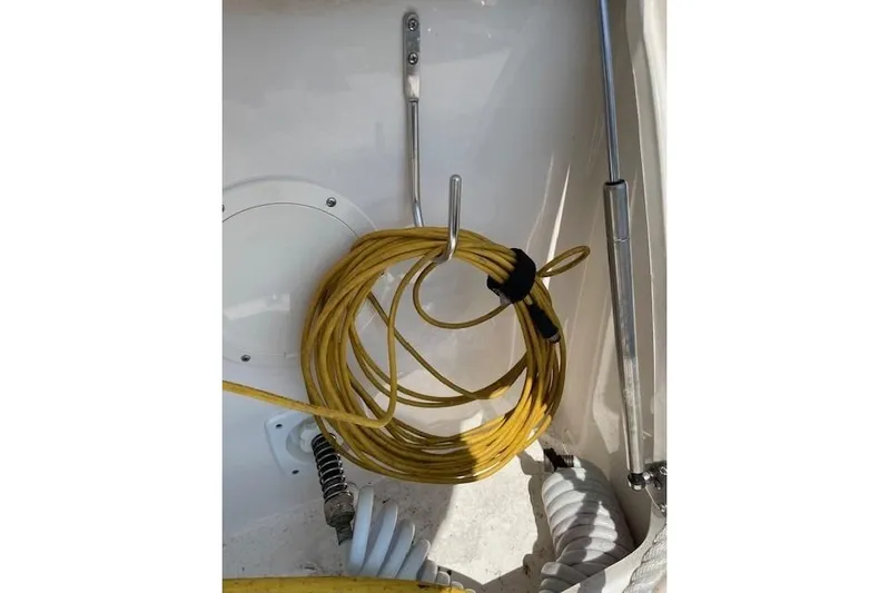 Seahorse Yacht Photos Pics Yellow cable coiled on a 2007 Chaparral 330 Signature boat, secured with metal hooks.
