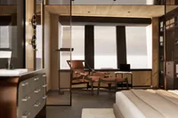 Modern bedroom with sleek furniture, large windows, and a cozy lounge chair, 2026 design.