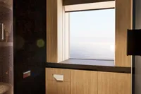 Modern bathroom with ocean view, wooden cabinets, and sleek design, 2026 custom model.