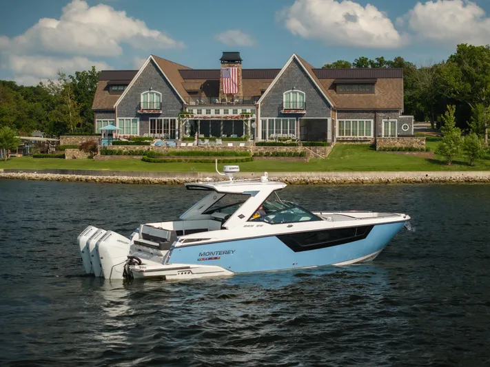  Yacht Photos Pics 2024 Monterey 385SS boat on water, elegant house in background, sunny day.