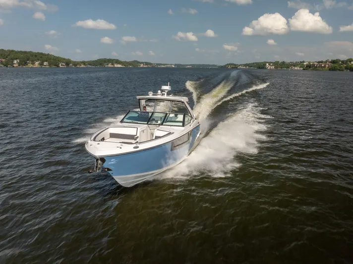 Yacht Photos Pics 2024 Monterey 385SS boat cruising on a lake under a clear blue sky.
