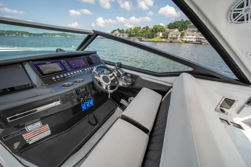  Yacht Photos Pics 2024 Monterey 385SS boat cockpit with modern controls and scenic lake view.