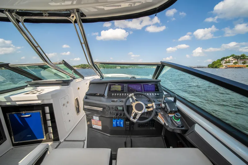  Yacht Photos Pics 2024 Monterey 385SS boat cockpit with modern controls, steering wheel, and scenic water view.