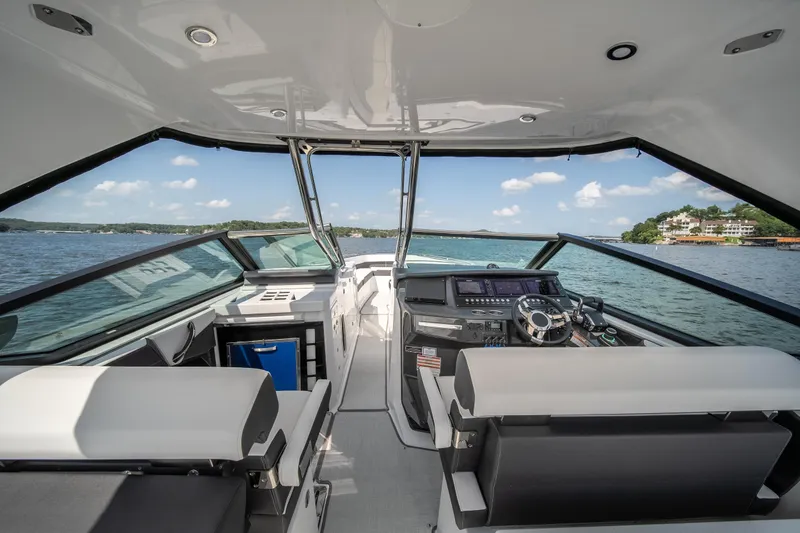  Yacht Photos Pics 2024 Monterey 385SS boat interior with modern helm, seating, and scenic lake view.