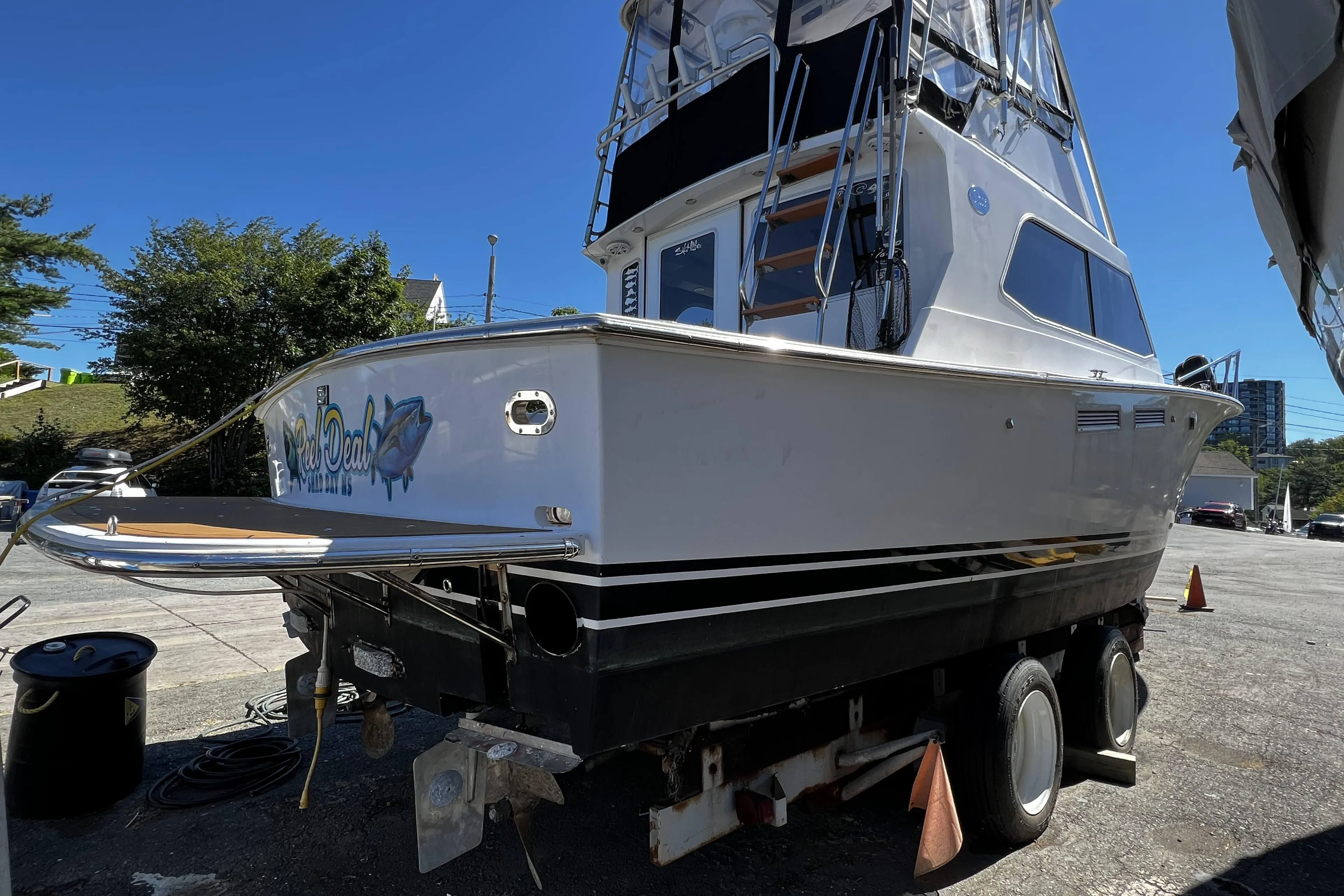 1988 Pace 40 Sport Fisherman boat on trailer, parked outdoors under clear blue sky.
