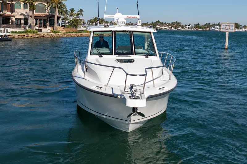  Yacht Photos Pics 2015 Boston Whaler 345 Conquest boat cruising on a sunny day near waterfront homes.