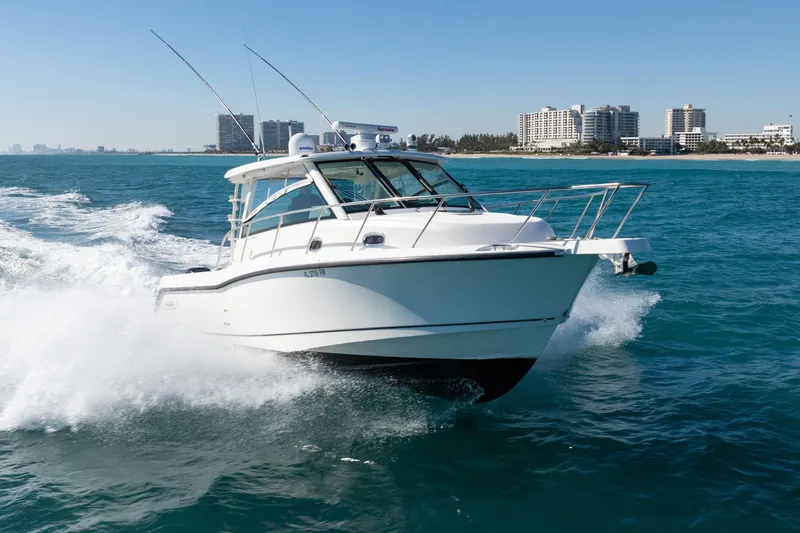  Yacht Photos Pics 2015 Boston Whaler 345 Conquest cruising on ocean near city skyline.