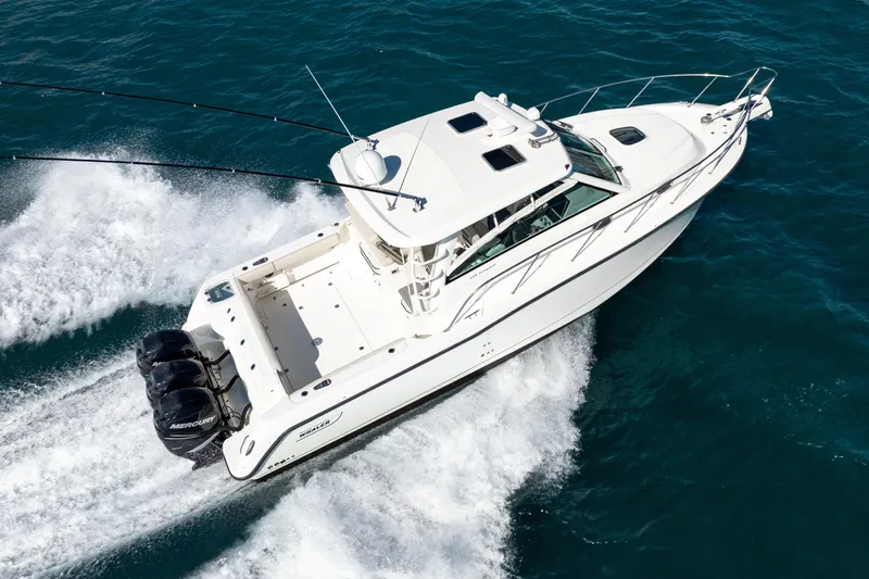  Yacht Photos Pics 2015 Boston Whaler 345 Conquest cruising on open water, aerial view.