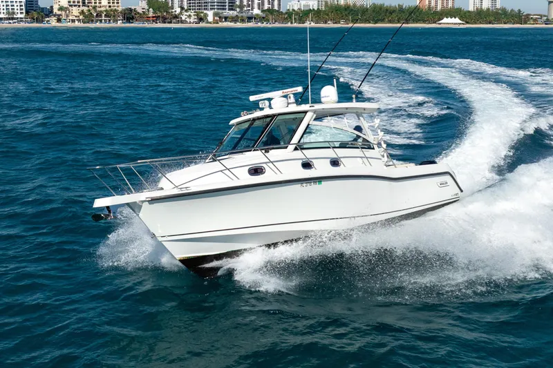  Yacht Photos Pics 2015 Boston Whaler 345 Conquest cruising on open water, cityscape in background.