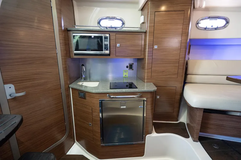  Yacht Photos Pics 2015 Boston Whaler 345 Conquest interior kitchen with microwave, sink, and seating area.