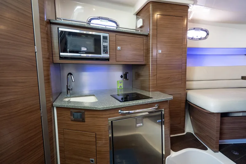  Yacht Photos Pics 2015 Boston Whaler 345 Conquest interior kitchen with microwave, sink, and modern cabinetry.