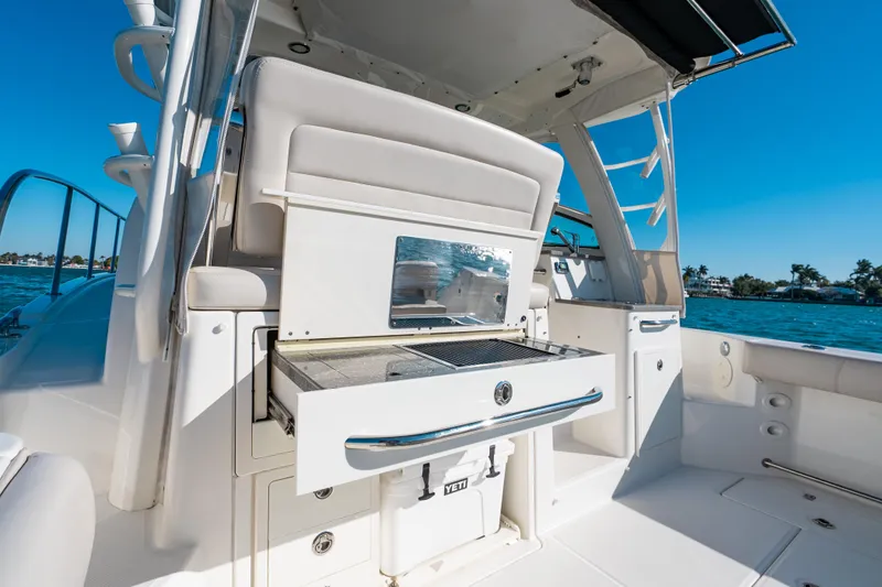  Yacht Photos Pics 2015 Boston Whaler 345 Conquest boat interior with grill and storage, docked by the water.
