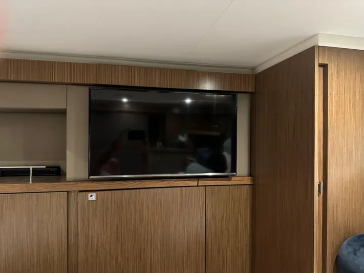 Graceful Yacht Photos Pics Interior of 2017 Sea Ray Sundancer 460 with mounted TV and wooden cabinetry.
