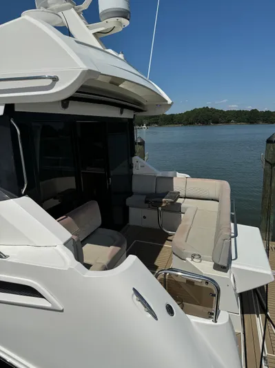 Graceful Yacht Photos Pics 2017 Sea Ray Sundancer 460 yacht with spacious deck and seating, docked by a serene lake.