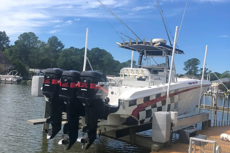  Yacht Photos Pics 2003 Fountain 38TE boat with triple Mercury outboard engines docked on a lift.